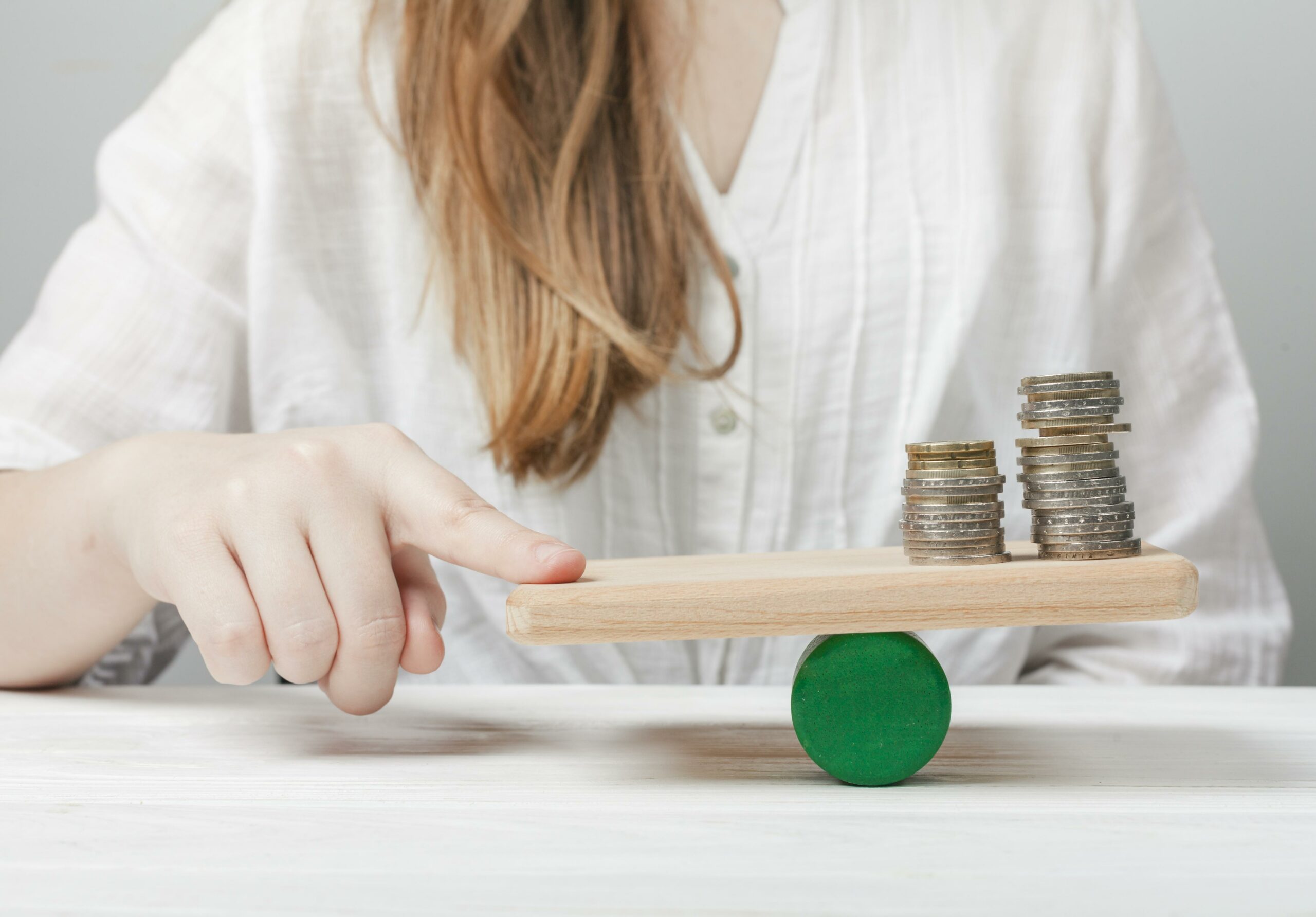 femme-tenant-son-doigt-en-équilibre-avec-les-pièces