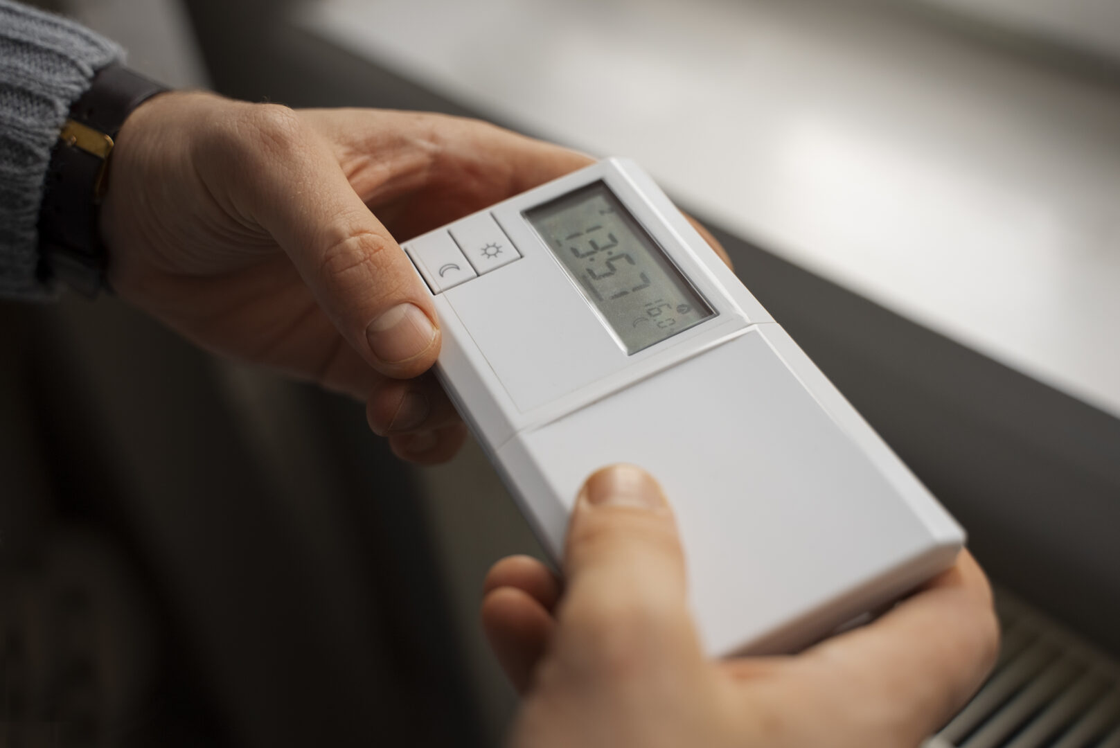 homme avec thermostat pour plus de chauffage