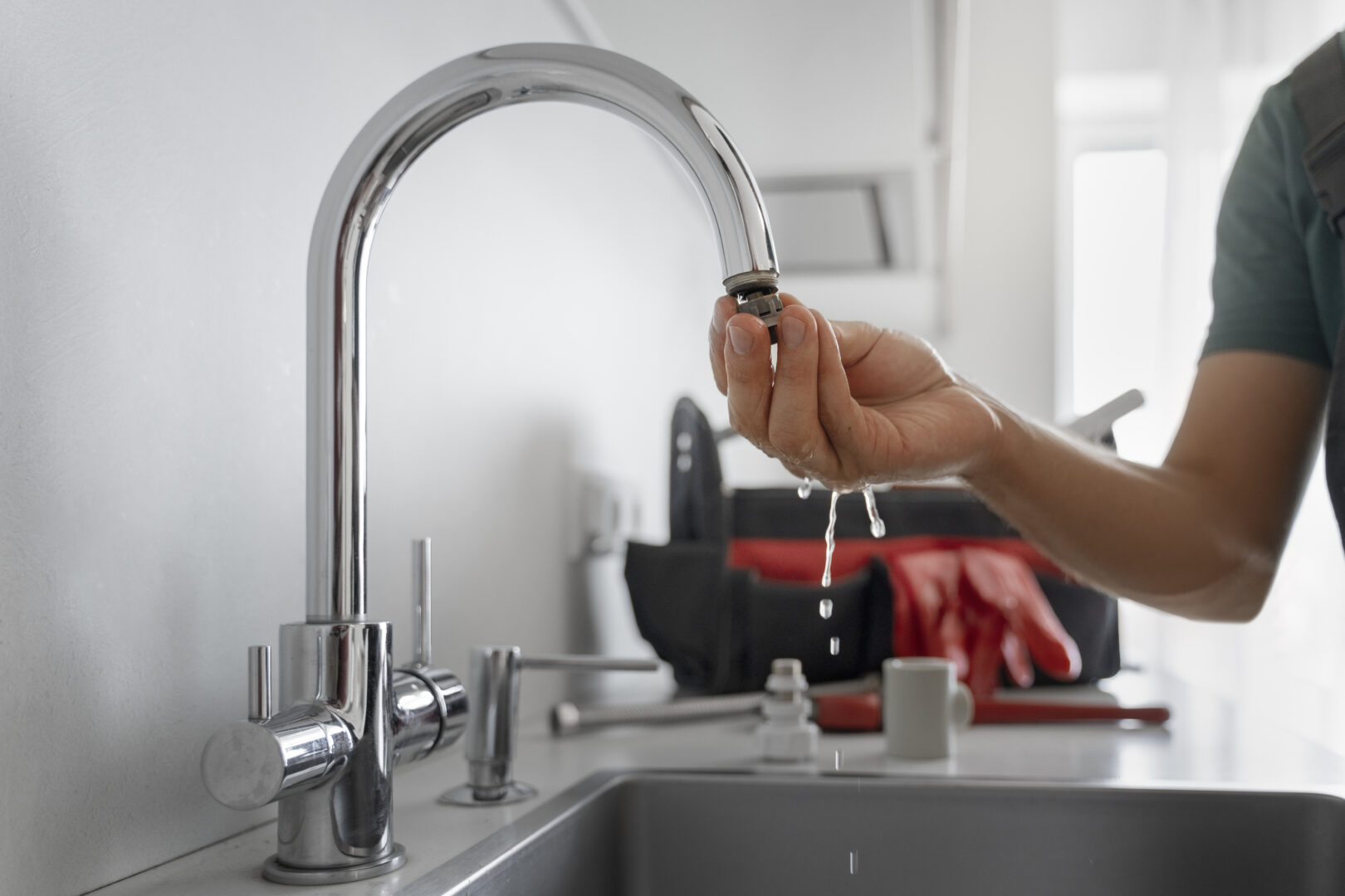 homme qui essaye de réparer son robinet qui goutte